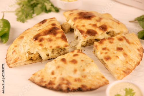 Stuffed naan desi pizza with Chicken herbs vegetables and Cheese © Yell Design