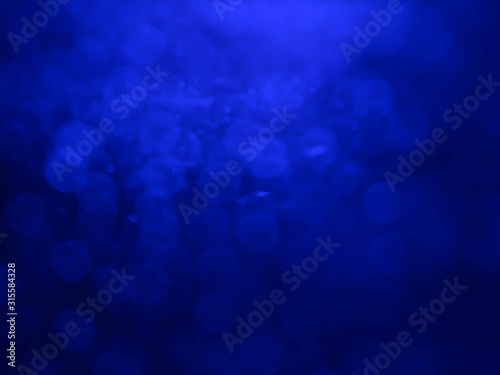 Abstract bokeh festoon on dark blue background.Blurred bright light.