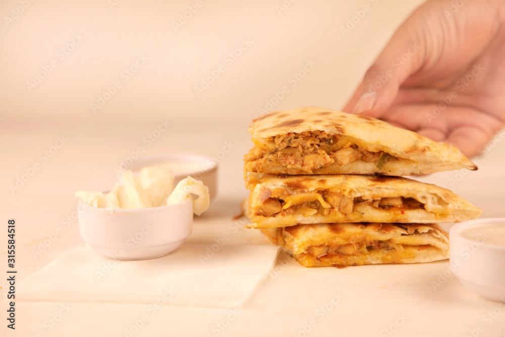 Hand picking slice of Butter Chicken Stuffed Naan Hand picking slice of Butter Chicken Stuffed Naan