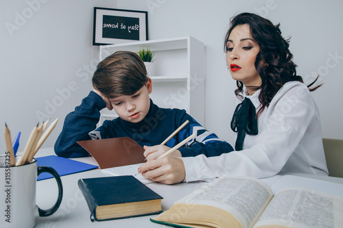 Foto Young teacher trying to explain information to the boy