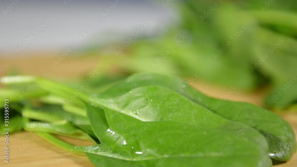 slices with a knife fresh green spinach leaves for salad. slices with a knife fresh green spinach leaves for salad.
