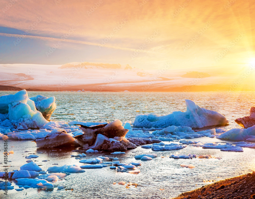 Magical landscape with ice deep in the form of a shark in the famous Jokulsarlon glacial lagoon in Iceland at sunset. Exotic amazing places. Popular tourist atraction. (global warming – concept)