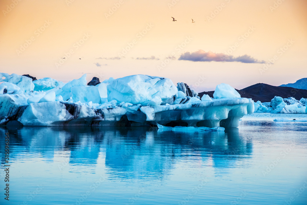 Magical landscape with ice depths in the famous Jokulsarlon glacial lagoon in Iceland at sunset. Exotic countries. Amazing places. Popular tourist atraction. (global warming – concept)