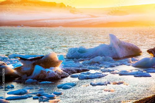 Magical landscape with ice deep in the form of a shark  in the famous Jokulsarlon glacial lagoon in Iceland at sunset. Exotic amazing places. Popular tourist atraction. (global warming – concept)