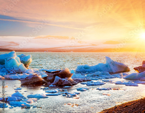 Obraz na płótnie Magical landscape with ice deep in the form of a shark in the famous Jokulsarlon glacial lagoon in Iceland at sunset. Exotic amazing places. Popular tourist atraction. (global warming – concept) w salonie