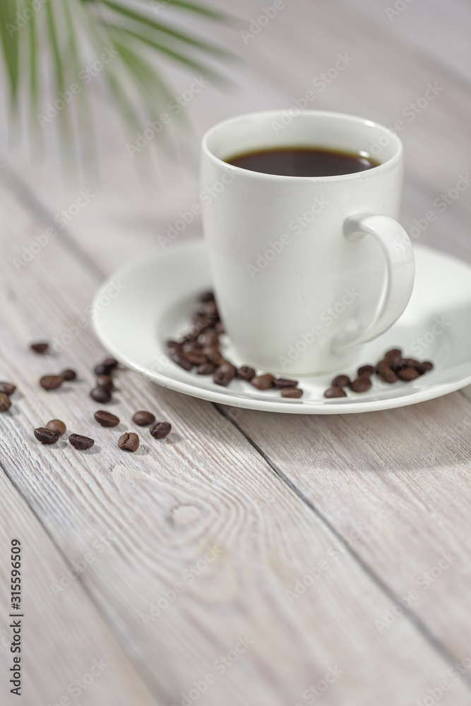 Close up a cup of hot coffee with roasted coffee beans on white wooden table. Close up a cup of hot coffee with roasted coffee beans on white wooden table.