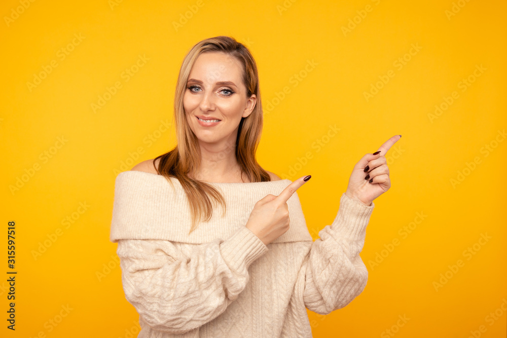 Young attractive woman pointing by fingers isolated Young attractive woman pointing by fingers isolated