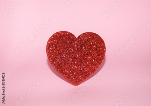 Valentine's Day love concept, single red glitter heart on pink background. St. Valentine's Day concept background with copy space. Valentine's Day background