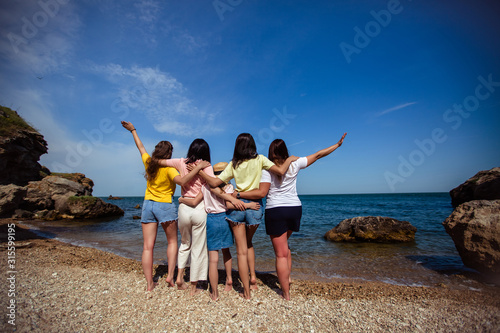 summer, sea, island, coast. Happy Family Hugging Each Other And Holding Hands Up. back view