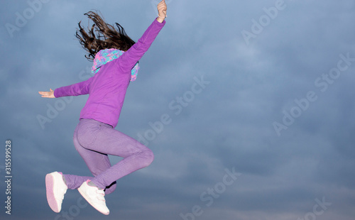 girl jumping in the air on a winter's night © FranciscoJavier