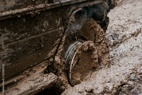 close of view of a very muddy wheel after off road driving through the dirt and mud.