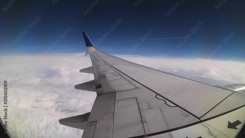 An airplane jets by leaving a trail of white smoke just above the aircraft that we are inside. Captured in 4K time-lapse above the clouds. An airplane jets by leaving a trail of white smoke just above the aircraft that we are inside. Captured in 4K time-lapse above the clouds.