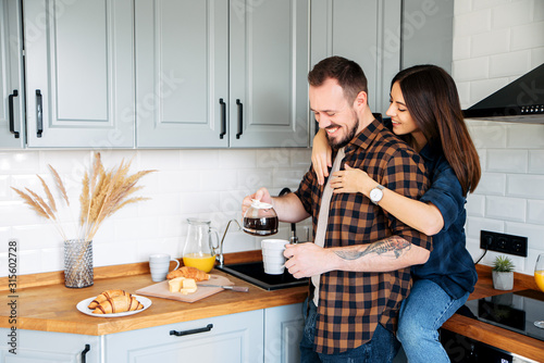 Loving couple in a stylish gray kitchen