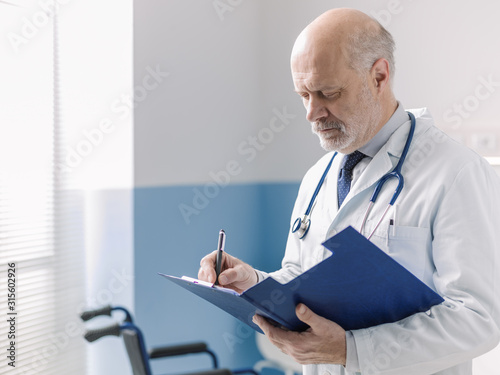 Doctor writing a medical prescription on a clipboard