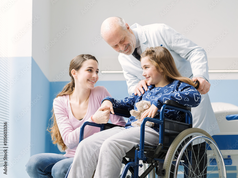 Doctor assisting a patient in wheelchair and her mother Doctor assisting a patient in wheelchair and her mother