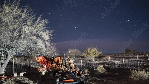 Timelapse at night with stars moving in the background. Old broken down tractor in the foreground. Namibia sheep farm. photo