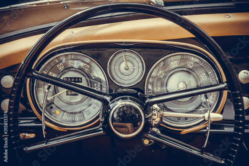 Tachometer, speedometer, clock and various gauges on a vintage car's dashboard