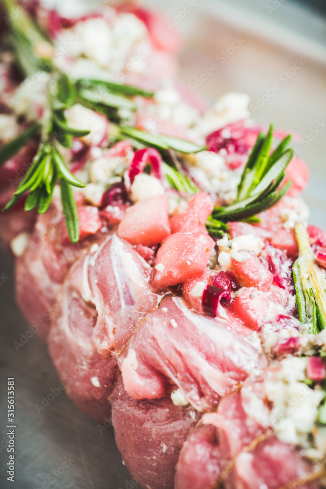 Raw pork loin with fruits, blue cheese and rosemary ready for baking. Selective focus. Shallow depth of field. Raw pork loin with fruits, blue cheese and rosemary ready for baking. Selective focus. Shallow depth of field.