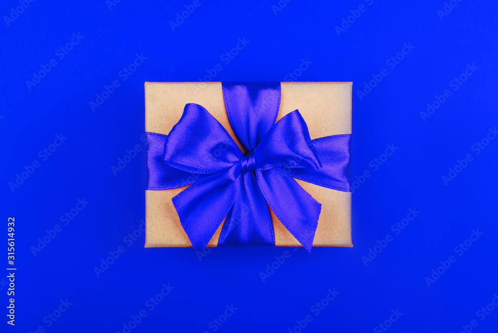 Cardboard gift box with bow on red background. Flat lay. Top view.