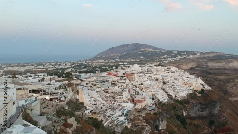 Aerial view on the Fira capital of Santorini at summer evening. Low light raw footage Aerial view on the Fira capital of Santorini at summer evening. Low light raw footage