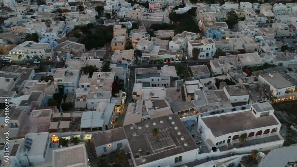 Aerial view on the Fira capital of Santorini at summer evening. Low light raw footage Aerial view on the Fira capital of Santorini at summer evening. Low light raw footage