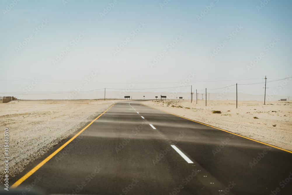Road next to the Sahara desert during a sandstorm