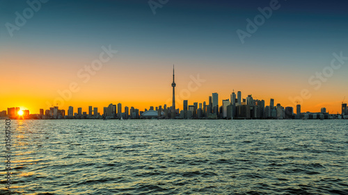 Toronto city skyline at sunset with CN Tower over Ontario Lake, Canada
