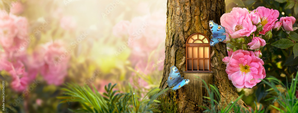 Fototapeta premium Zaczarowany bajkowy las z magicznym lśniącym oknem w zagłębieniu fantazyjnego domu elfów sosny, kwitnący bajeczny olbrzymi różowy kwiat róży ogród, latający magiczny niebieski motyl pawich oczu, kopia przestrzeń