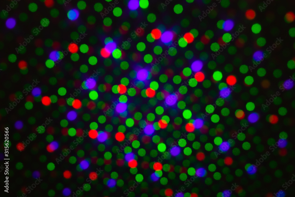 Abstract dot defocus background backdrop, rainbow colored green red violet round glitter on black background. Illumination blurry lights, abstract light spots