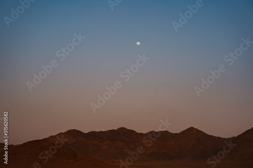 moon over NamibRand mountains in Namibia, Africa