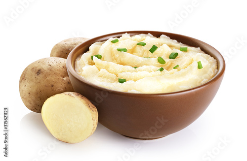Bowl with mashed potatoes and raw potatoes isolated on white background.