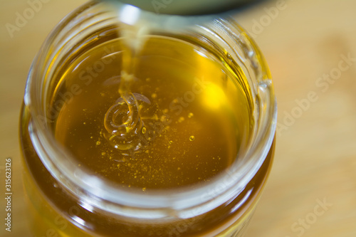fresh honey flows into a jar