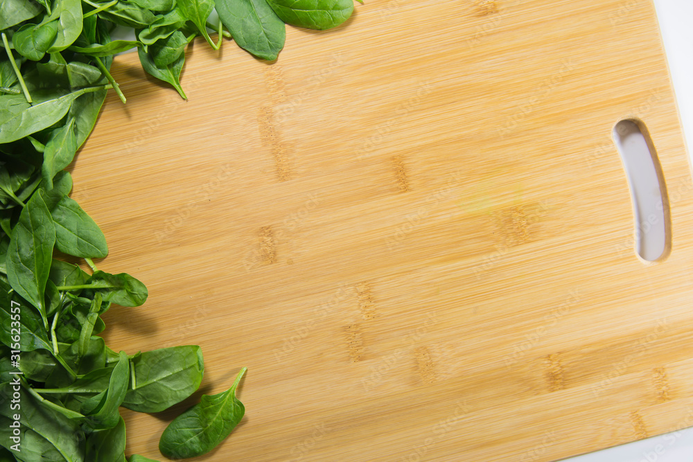 зеленыые листья шпината лежат на деревянном столе. Здоровая пища