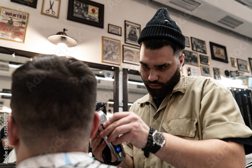Men's haircut. Stylish hairdresser cuts a man.