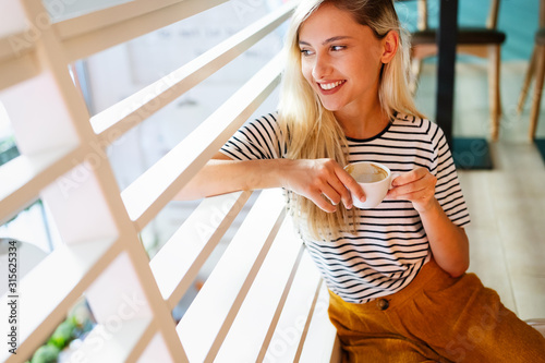Free Download Beautiful woman enjoying a cup of coffee while relaxing at home. - GFXLoad