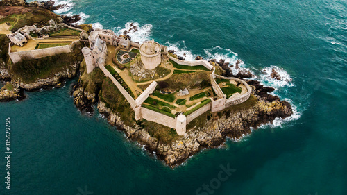 Aerial view from drone of the stunning  Fort La Latte in Brittany (Bretagne) in France on the Peninsula that washes the Atlantic ocean-a picturesque coastline with a fortress and emerald-colored water photo