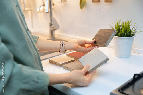 kitchen interior design - woman selecting furniture material texture photo