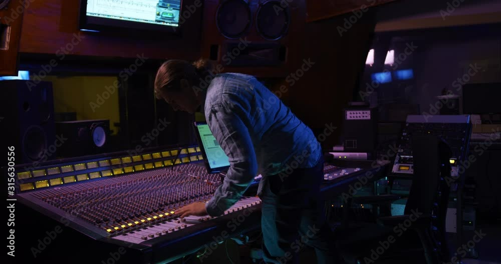 Male sound engineer working at a mixing desk Male sound engineer working at a mixing desk