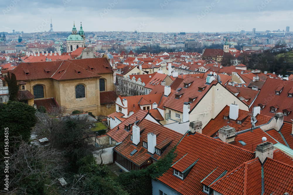 Panoramic view of Prague, the capital of the Czech Republic, and the Vltava river, traditional red rooftops from one of the Prague hills in late autumn Panoramic view of Prague, the capital of the Czech Republic, and the Vltava river, traditional red rooftops from one of the Prague hills in late autumn