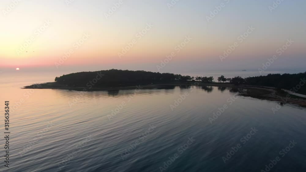 Coastline beaches of Cervar Croatia with forest areas near the Adriatic sea at sunset, drone aerial right pan reveal shot Coastline beaches of Cervar Croatia with forest areas near the Adriatic sea at sunset, drone aerial right pan reveal shot