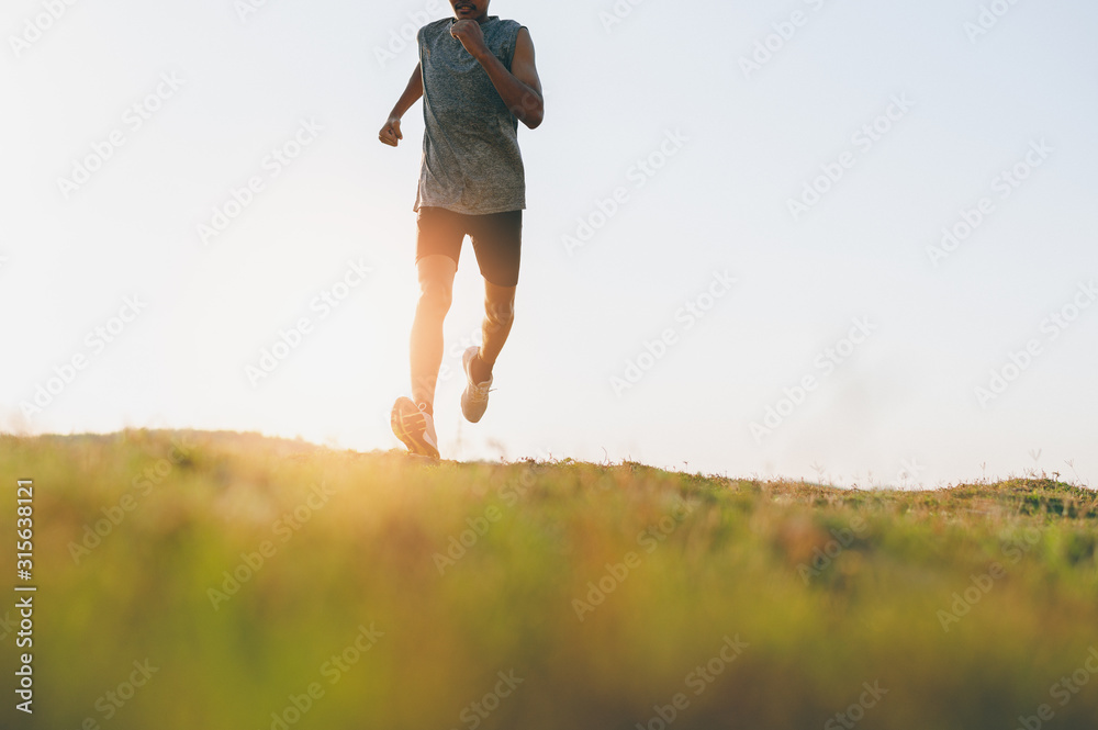 Fototapeta premium Athlete runner feet running on road, Jogging at outdoors. Man running for exercise.Sports and healthy lifestyle concept.