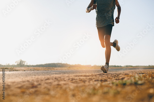 Fototapeta Naklejka Na Ścianę i Meble -  Athlete runner feet running on road, Jogging at outdoors. Man running for exercise.Sports and healthy lifestyle concept.