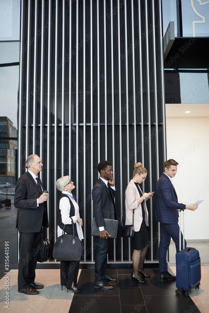 Φωτογραφία Group of business people with luggage standing in the queue and waiting for thei