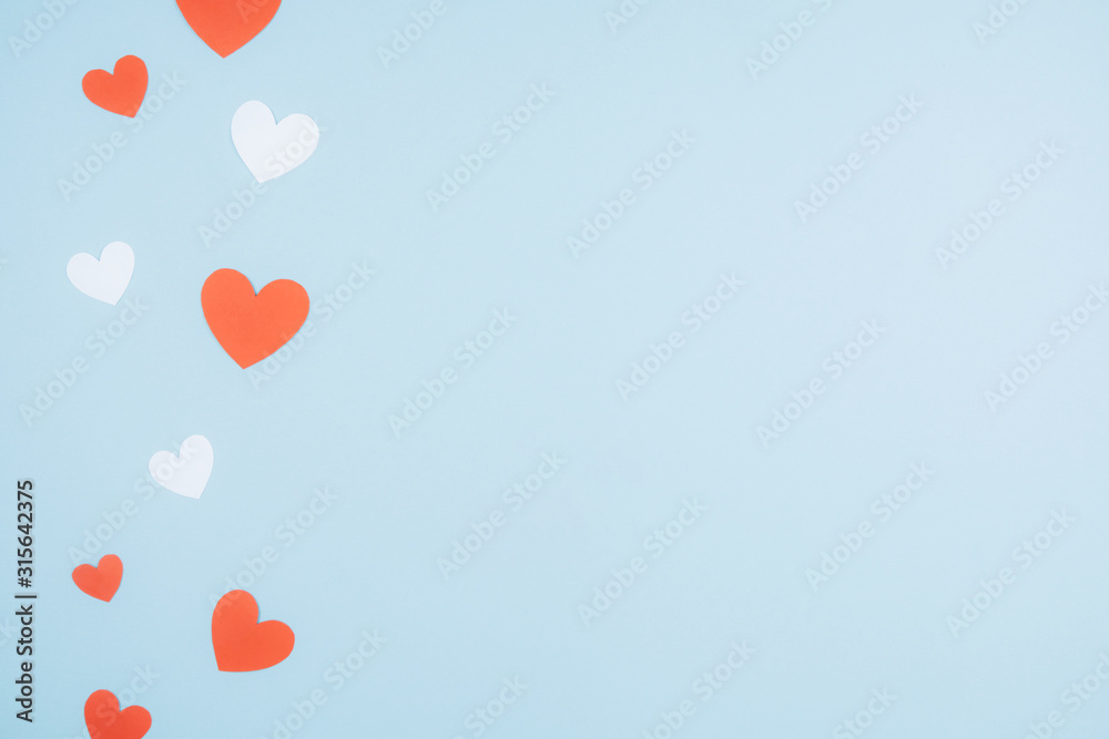 Blue background with red and white paper hearts. Space for text.