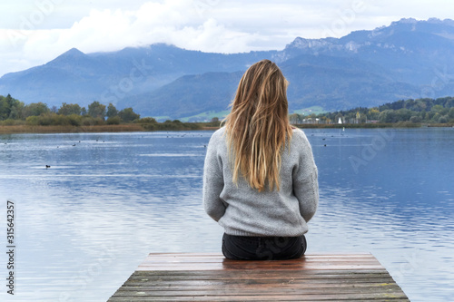 Woman in a jetty facing the lake