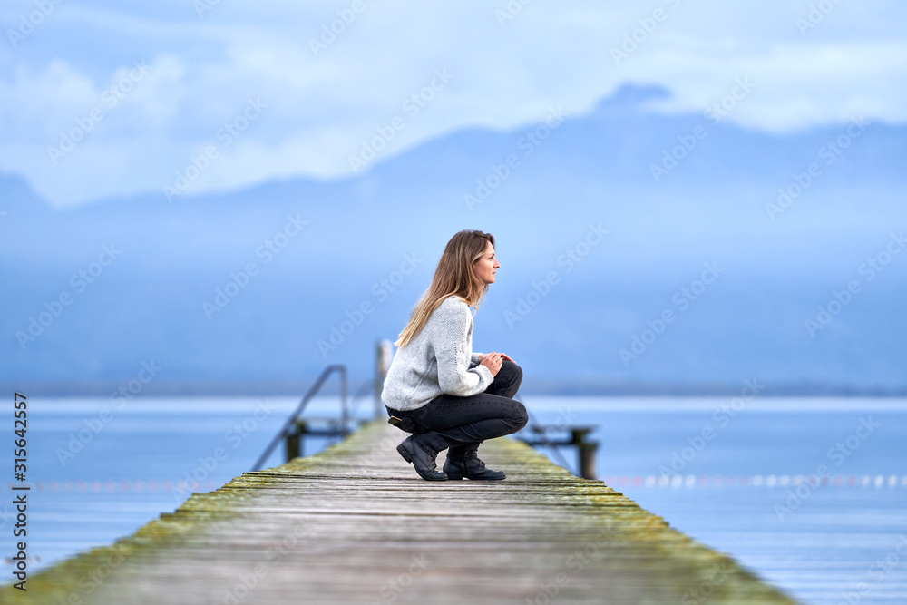 Woman in a jetty facing the lake