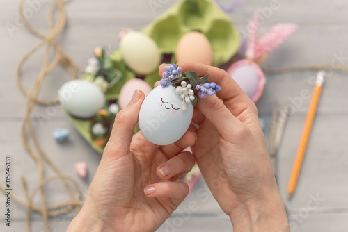 woman makes cute decorative eggs for easter holiday. do-it-yourself easter gifts concept. cute pastel colored eggs photo