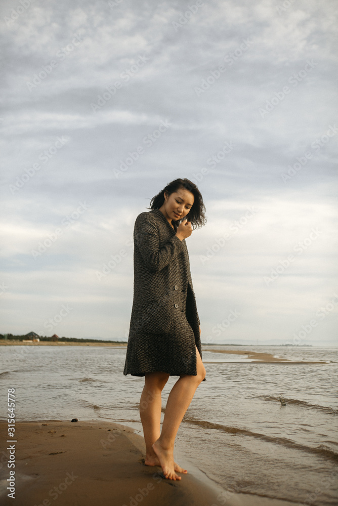Woman portrait in coat on sea beach Woman portrait in coat on sea beach