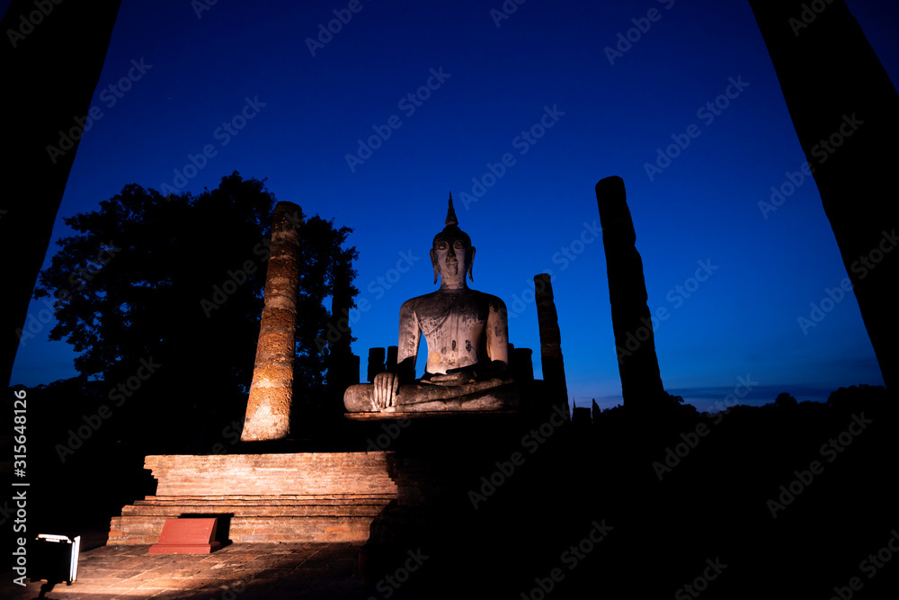 Silhouette of  Buddha image at Wat Mahathat in Sukhothai Historical Park, Thailand. Buddha statue used as amulets of Buddhism religion. Sukhothai Historic Park, Thailand.