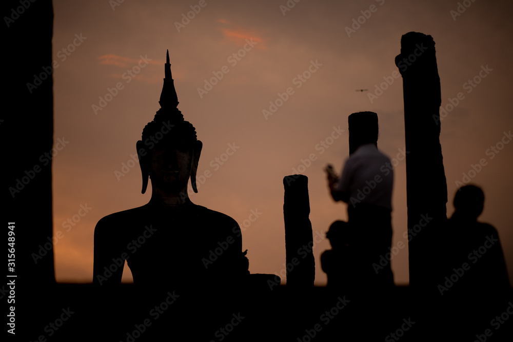 Silhouette of  Buddha image at Wat Mahathat in Sukhothai Historical Park, Thailand. Buddha statue used as amulets of Buddhism religion. Sukhothai Historic Park
